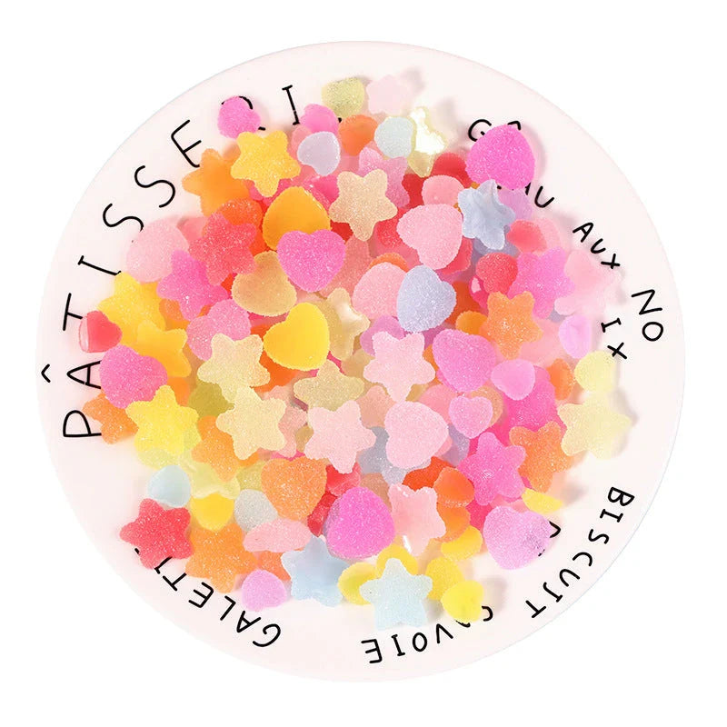 Heart and star-shaped nail charms with candy-inspired designs for creating unique and eye-catching nail art