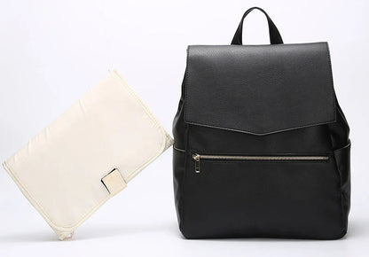 A stylish and practical PU leather mummy bag with a large capacity, multiple pockets, and included accessories like a changing pad and stroller hooks.