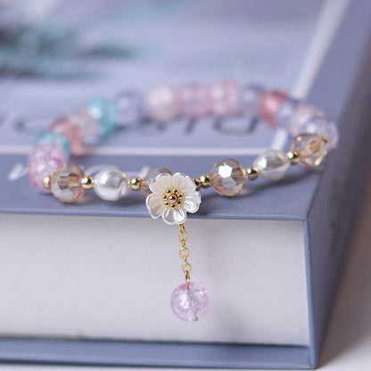 Elegant beaded bracelet with a white flower charm, vibrant purple crystal beads, and an adjustable design for a comfortable fit