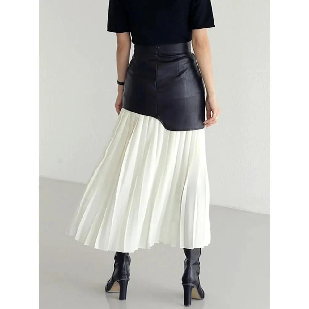 A stylish long pleated skirt featuring a sophisticated leather patchwork design and a flattering A-line silhouette
