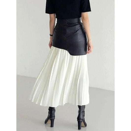 A stylish long pleated skirt featuring a sophisticated leather patchwork design and a flattering A-line silhouette