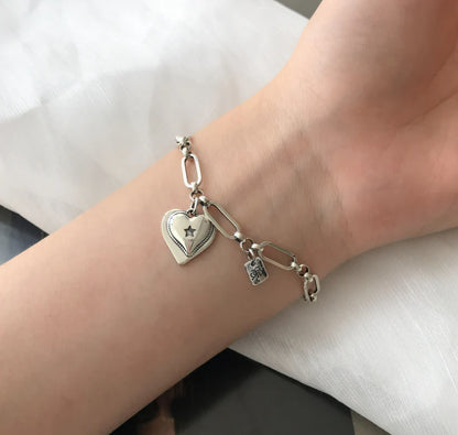 Elegant sterling silver bracelet with a delicate heart charm, a timeless accessory for the modern British woman.