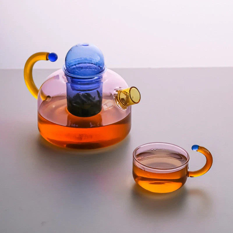 Elegant colourful glass teapot and teacup set with vibrant contrasting colours, perfect for tea and coffee enjoyment
