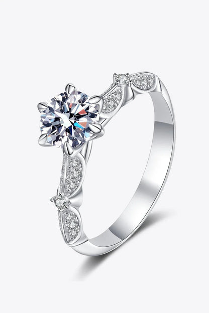 Closeup of an elegant sterling silver ring with a sparkling moissanite centre stone in a 6-prong setting