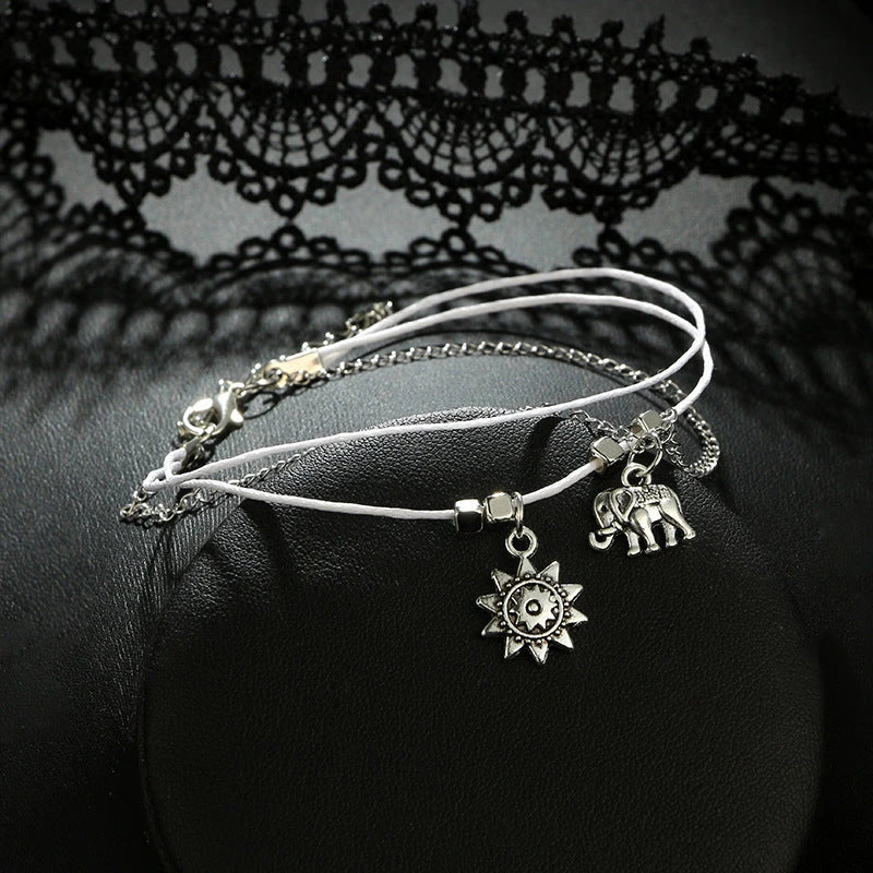 Elegant bohemian-style anklet with star and elephant charms in shimmering gold and silver tones