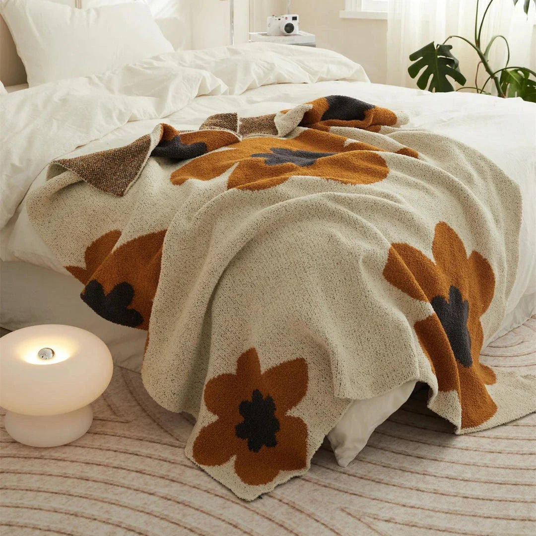 Cosy floral knitted throw blanket in red, featuring a chic bohemian design and luxurious microfibre fabric for maximum comfort and style.