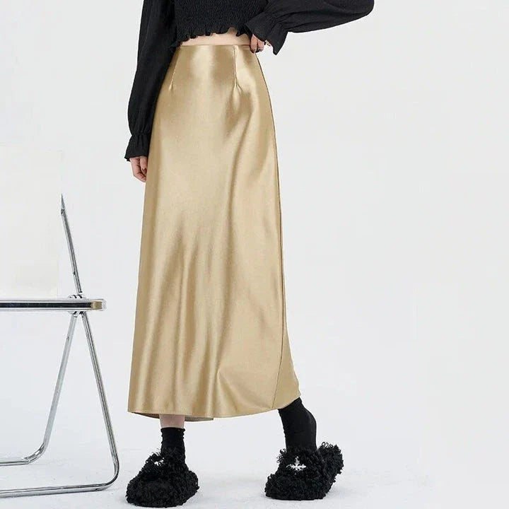 Luxurious silver satin maxi skirt with high-waist design and chic back split for elegant and versatile style.