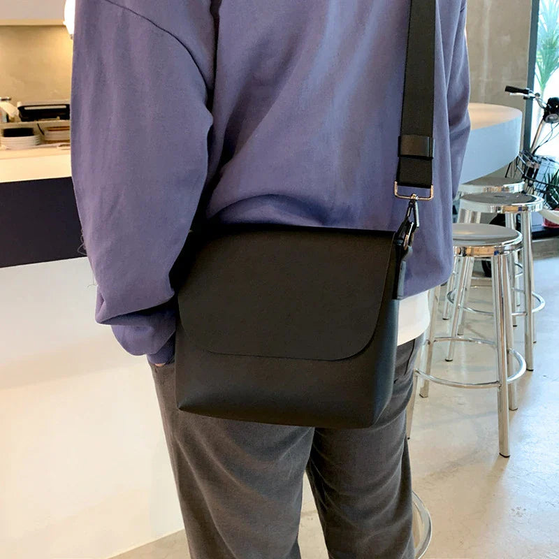Black PU leather messenger bag with adjustable strap and zippered pockets, a stylish and practical accessory for British gentlemen