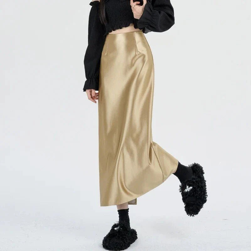 Luxurious silver satin maxi skirt with high-waist design and chic back split for elegant and versatile style.