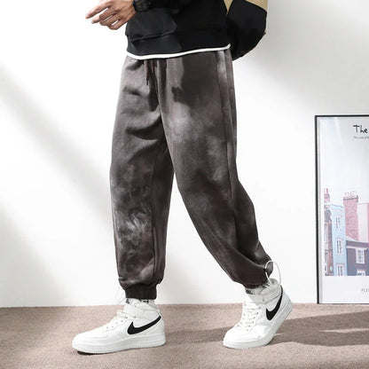 Stylish ankle-tied sweatpants in camouflage black, featuring an elasticated waistband, drawstring, and ankle ties for a relaxed yet refined look.