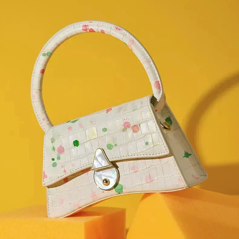 A stylish half-moon shaped genuine leather handbag with a decorative lock, showcasing premium British craftsmanship and timeless elegance.