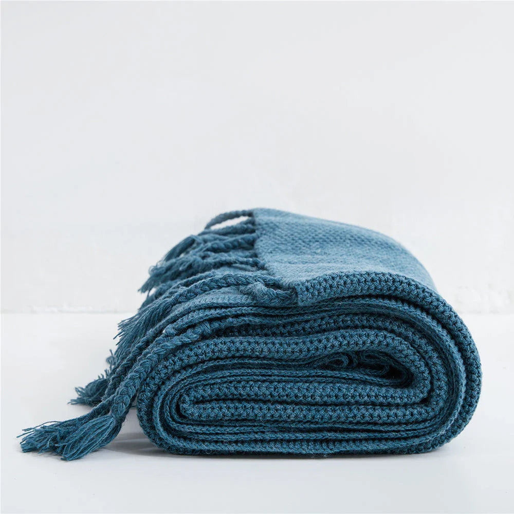 Luxurious Nordic-style wool knitted throw blanket in grey colour, featuring a solid pattern and elegant tassel design