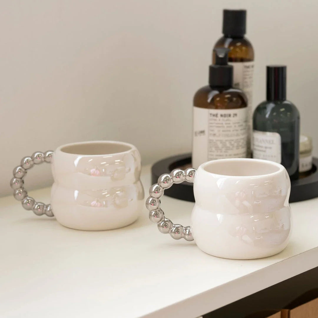 Handmade ceramic mug in beige and blue Nordic-inspired design, with a comfortable handle for enjoying hot or cold beverages.