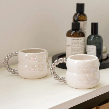 Handmade ceramic mug in beige and blue Nordic-inspired design, with a comfortable handle for enjoying hot or cold beverages.