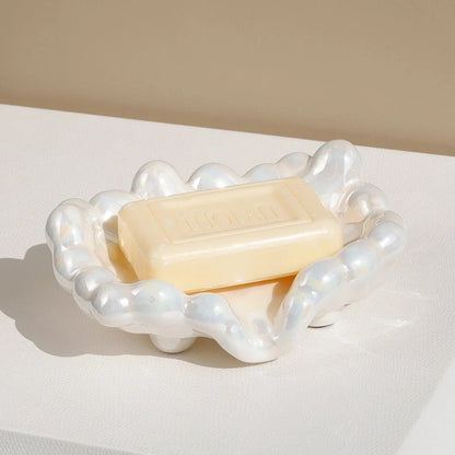 A ceramic soap dish with a whimsical cloud design, perfect for elevating your bathroom decor.