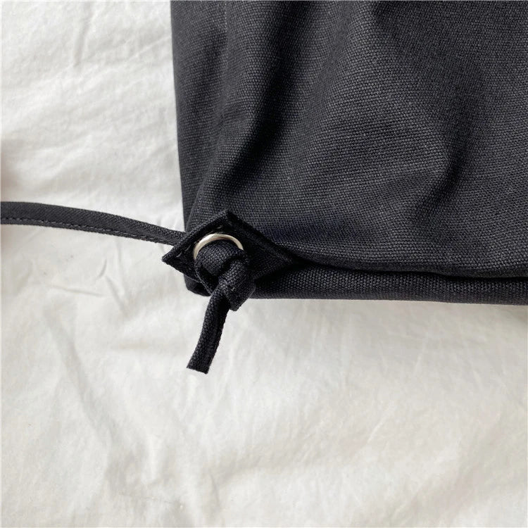 A stylish drawstring bucket bag in white, black, or brown colour options, featuring a spacious interior and adjustable closure for modern British women.