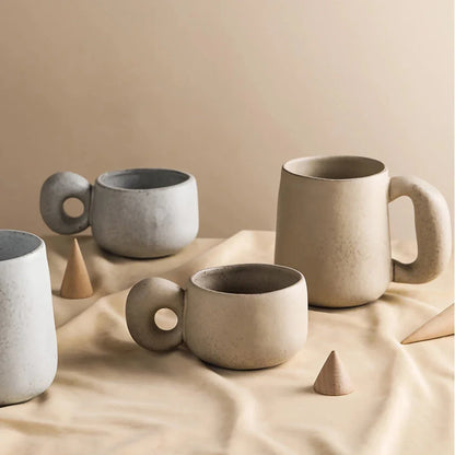Handcrafted Japanese ceramic retro coffee mug in solid apricot or grey colour, featuring a comfortable handgrip design for enhanced daily beverage enjoyment.