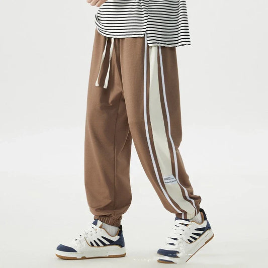 Plus-size men's loose sports trousers with ankle ties, made of premium polyester fabric in classic colours for versatile, comfortable activewear.