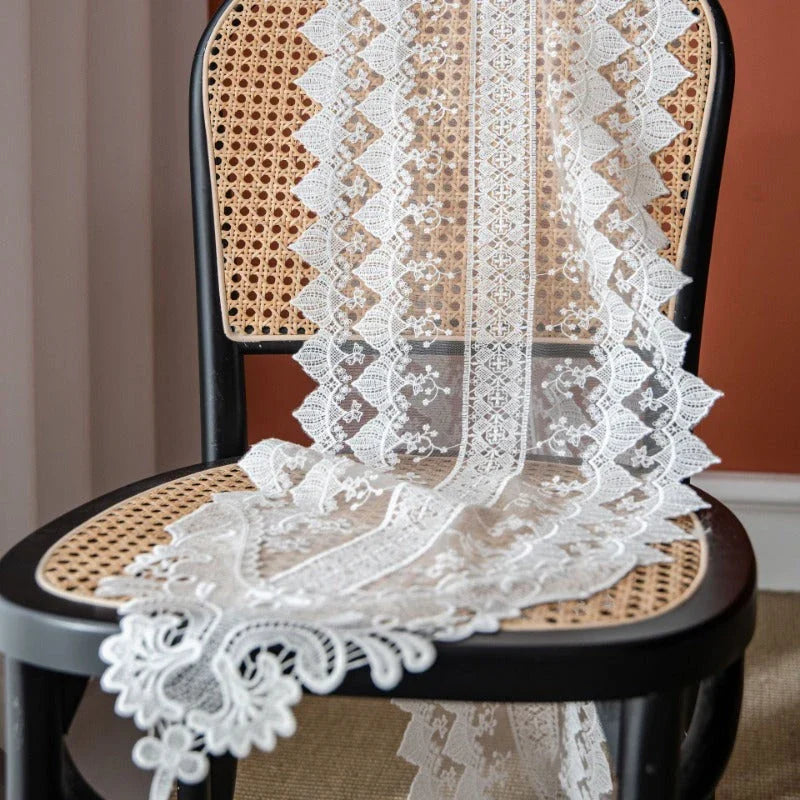 Elegant lace table runner with intricate embroidery and hollowed-out patterns, adding sophistication to any dining setting