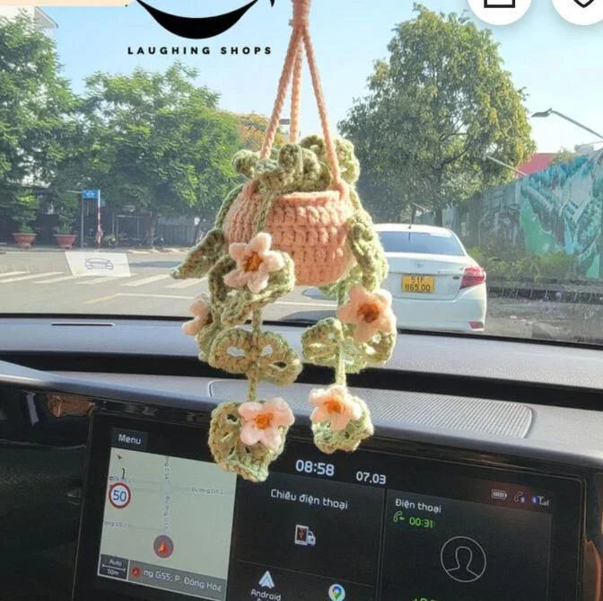 Charming knitted car plant decor with hanging white rope and green and white colour scheme