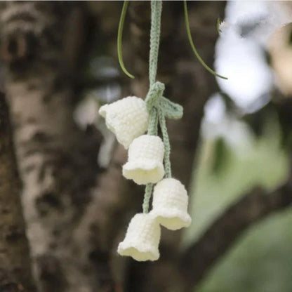 Charming knitted car plant decor with hanging white rope and green and white colour scheme