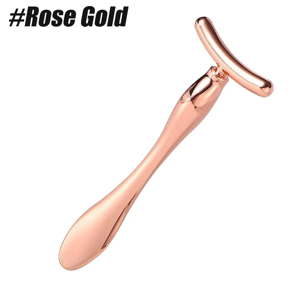 A rose gold metal eye cream applicator and face massager tool with a Y-shaped design for effective skincare application and facial massage