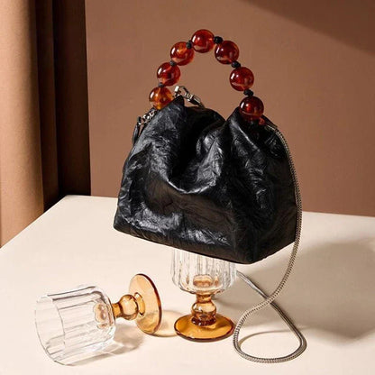 Premium leather crossbody bag with intricate beadwork, featuring a classic saddle shape and adjustable shoulder straps for versatile and secure everyday use.