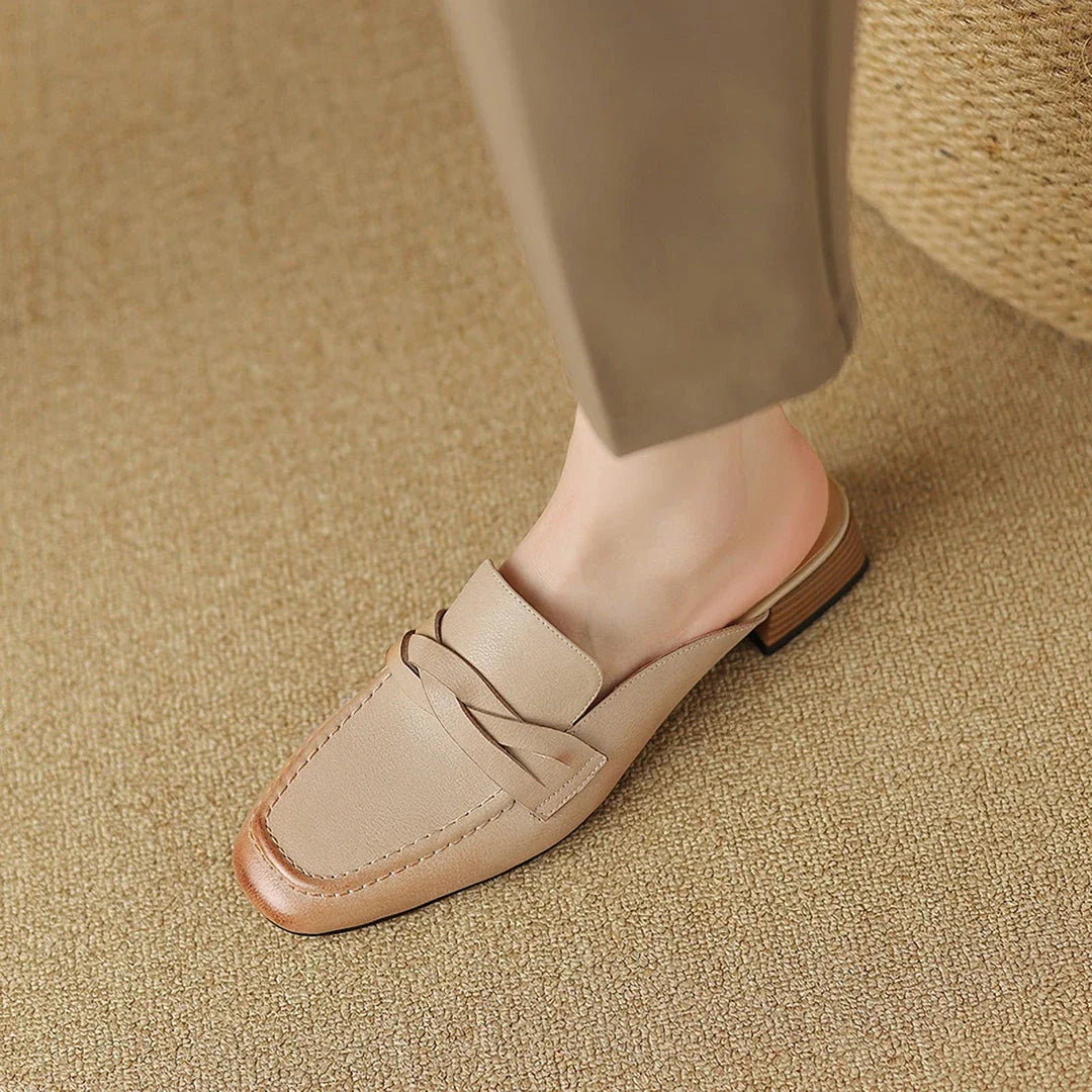 Stylish leather mules in a khaki colour, featuring a low square heel and a sleek, shallow-cut design for a retro-inspired, sophisticated look.