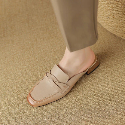 Stylish leather mules in a khaki colour, featuring a low square heel and a sleek, shallow-cut design for a retro-inspired, sophisticated look.