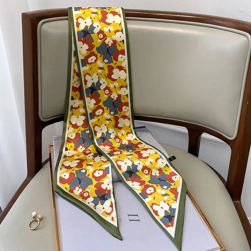 A vibrant floral-patterned silk-feel long scarf that can be worn as a neck accessory, hair tie, or wrist adornment for all occasions.