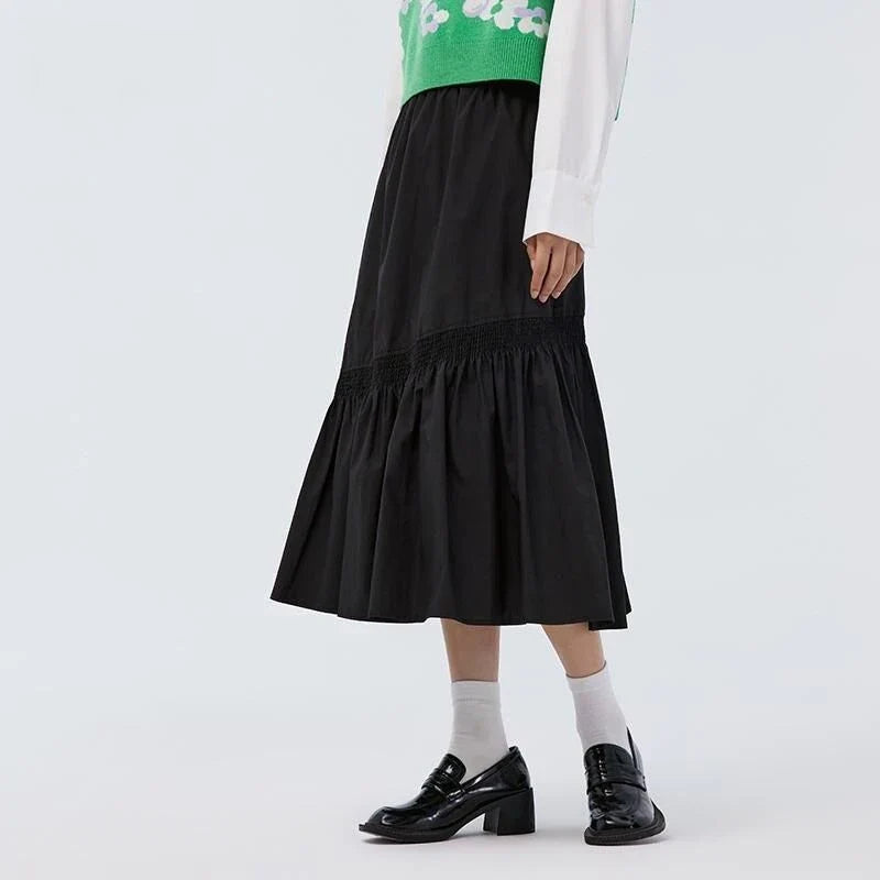 Elegant mid-length black skirt with an A-line silhouette, natural waistline, and unique irregular hemline, perfect for the modern British woman's wardrobe