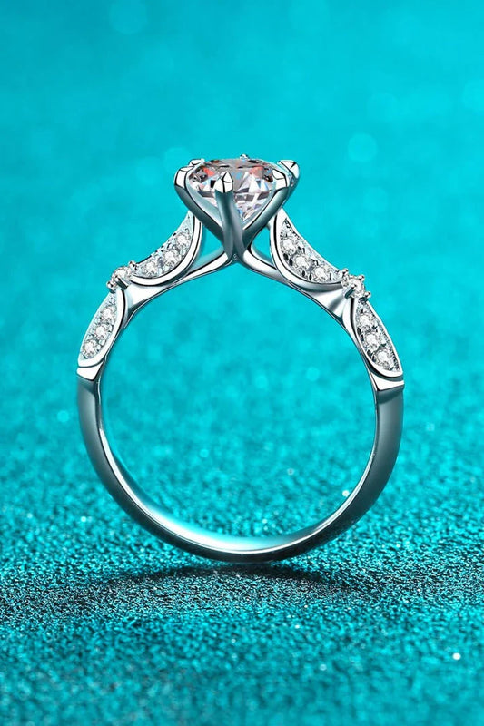 Closeup of an elegant sterling silver ring with a sparkling moissanite centre stone in a 6-prong setting