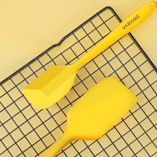 A set of two high-quality silicone spatulas in brown and yellow colours, designed for versatile cooking and baking tasks.