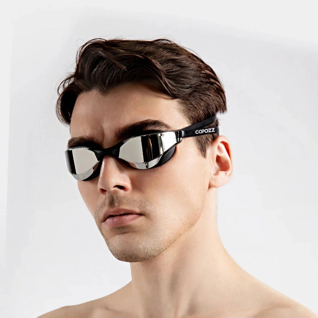 Premium British-made swimming goggles with anti-fog and UV protection technology, designed for clear visibility and comfort in pools, beaches, and water parks.