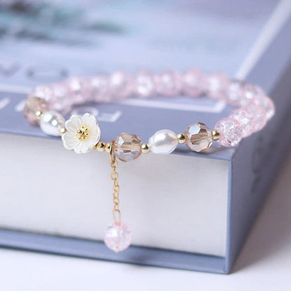 Elegant beaded bracelet with a white flower charm, vibrant purple crystal beads, and an adjustable design for a comfortable fit