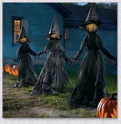 Three tall, black-robed witch figures with faceless glowing heads, standing together and holding hands, creating a spooky outdoor Halloween display