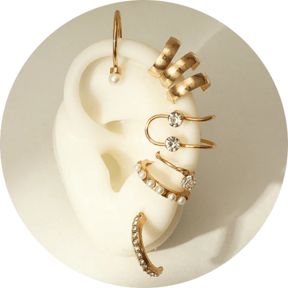 A set of 8 sophisticated gold-toned pearl stud earrings with unique, eye-catching designs