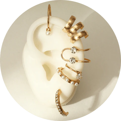 A set of 8 sophisticated gold-toned pearl stud earrings with unique, eye-catching designs