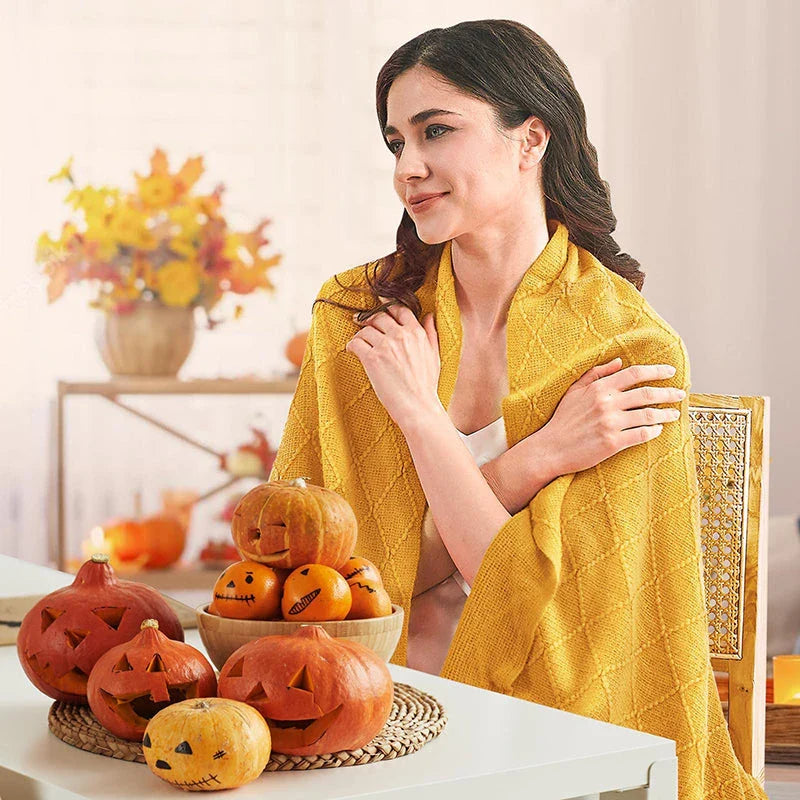 Cosy mustard yellow knitted throw blanket with raised diamond pattern and tassel fringes, providing soft and warm comfort for living rooms, bedrooms, and outdoor use.