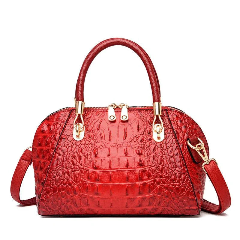Premium leather one-shoulder messenger bag in various colours, featuring a sleek, shell-inspired silhouette and multiple internal pockets for organisation.