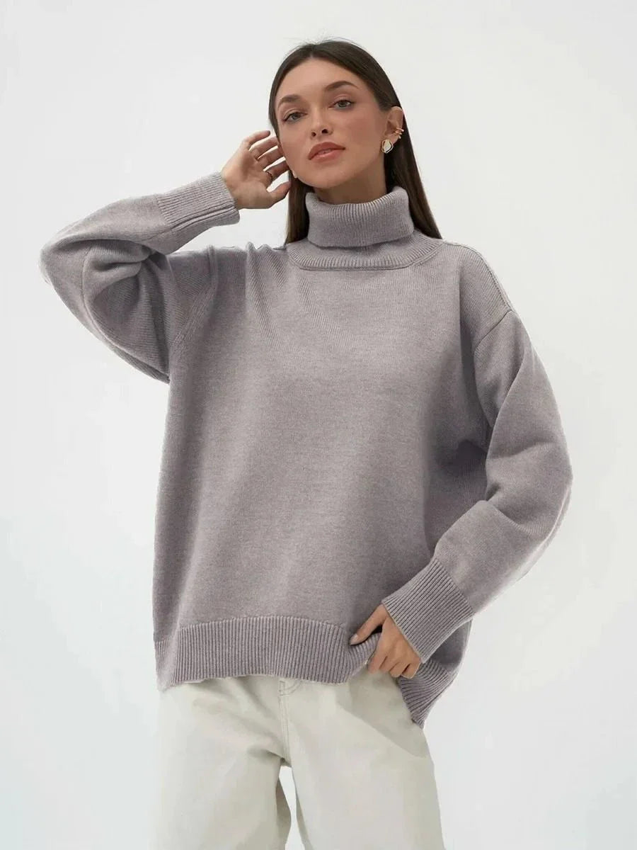 Cosy oversized knitted pullover in blue, featuring a classic turtleneck collar and drop-shoulder silhouette for maximum comfort and style.