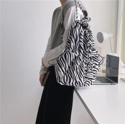 A stylish drawstring bucket bag in white, black, or brown colour options, featuring a spacious interior and adjustable closure for modern British women.
