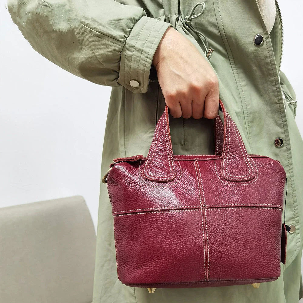 Premium leather shoulder bag for women in red, blue, and black colours with spacious interior and comfortable strap
