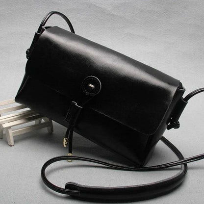 Premium leather crossbody bag in a sleek, horizontal square design with subtle car stitching details