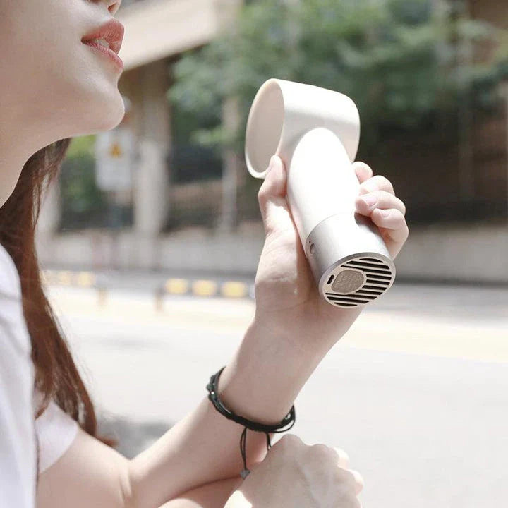 Compact, cordless, and bladeless fan with a sleek, white design and a powerful 900mAh battery for portable cooling.