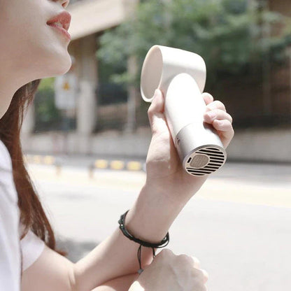 Compact, cordless, and bladeless fan with a sleek, white design and a powerful 900mAh battery for portable cooling.