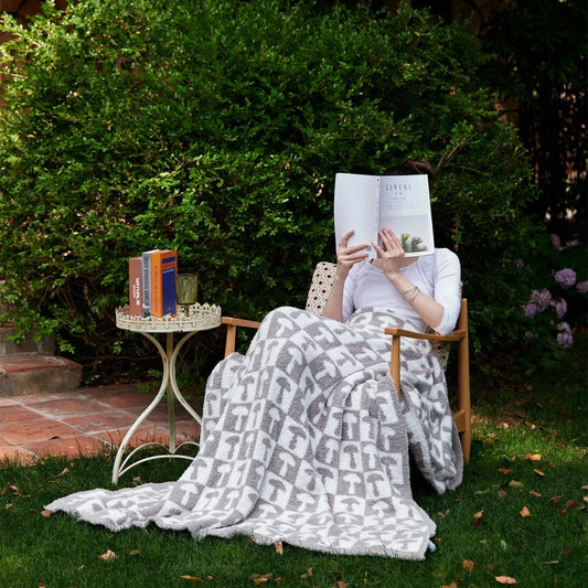 Cosy two-tone checkerboard plaid knitted throw blanket in various colours, including red, blue, grey, and purple