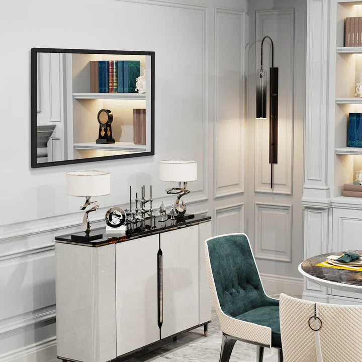 Sophisticated black metal framed wall mirror with rounded corners, reflecting a bright and spacious room