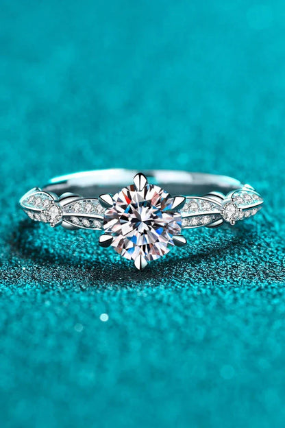 Closeup of an elegant sterling silver ring with a sparkling moissanite centre stone in a 6-prong setting