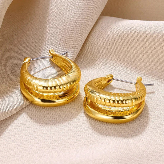A pair of gold-toned stainless steel hoop earrings, showcasing a classic and sophisticated design